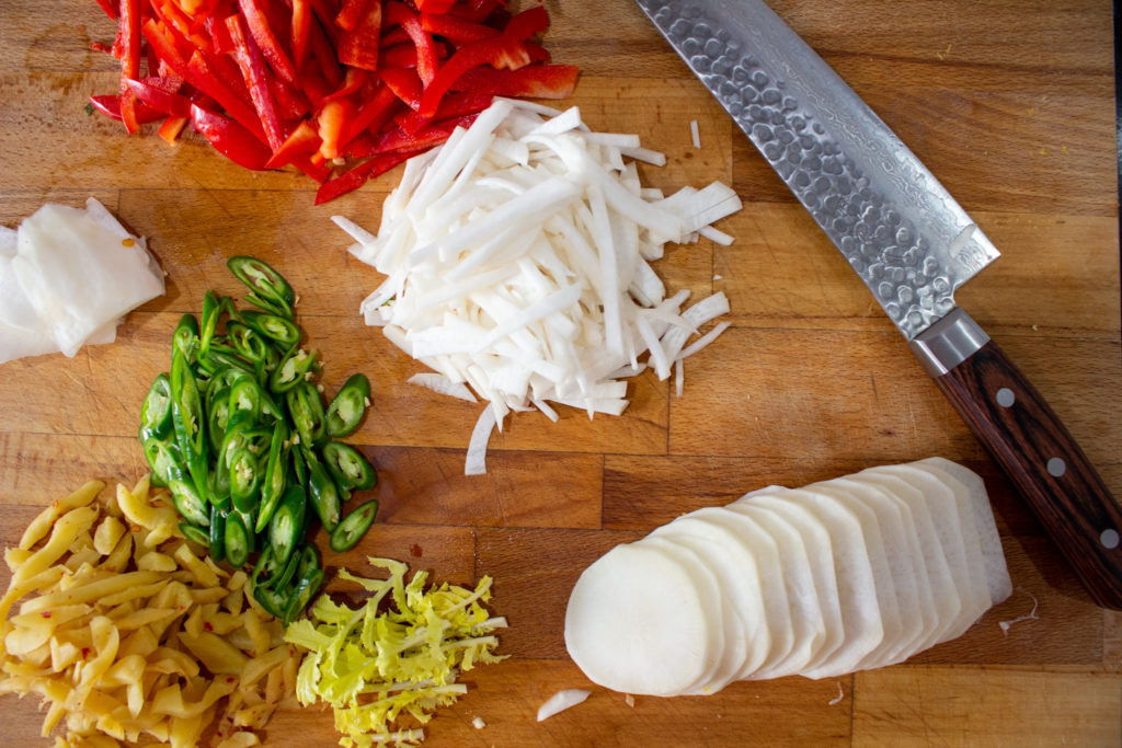 Wooden cutting board with a variety of Chinese knife cuts (rondelle and julienne)