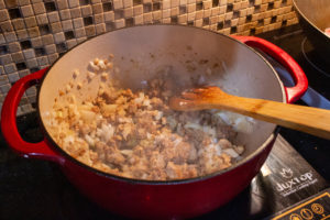 Cook onions with browned meat